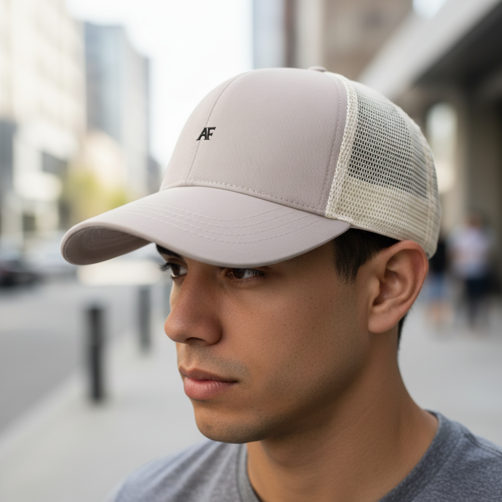 Atlas Form The Zephyr Cap in oyster oyster with cream mesh back, a minimalist trucker hat worn in an urban street setting, close-up focus on the cap.