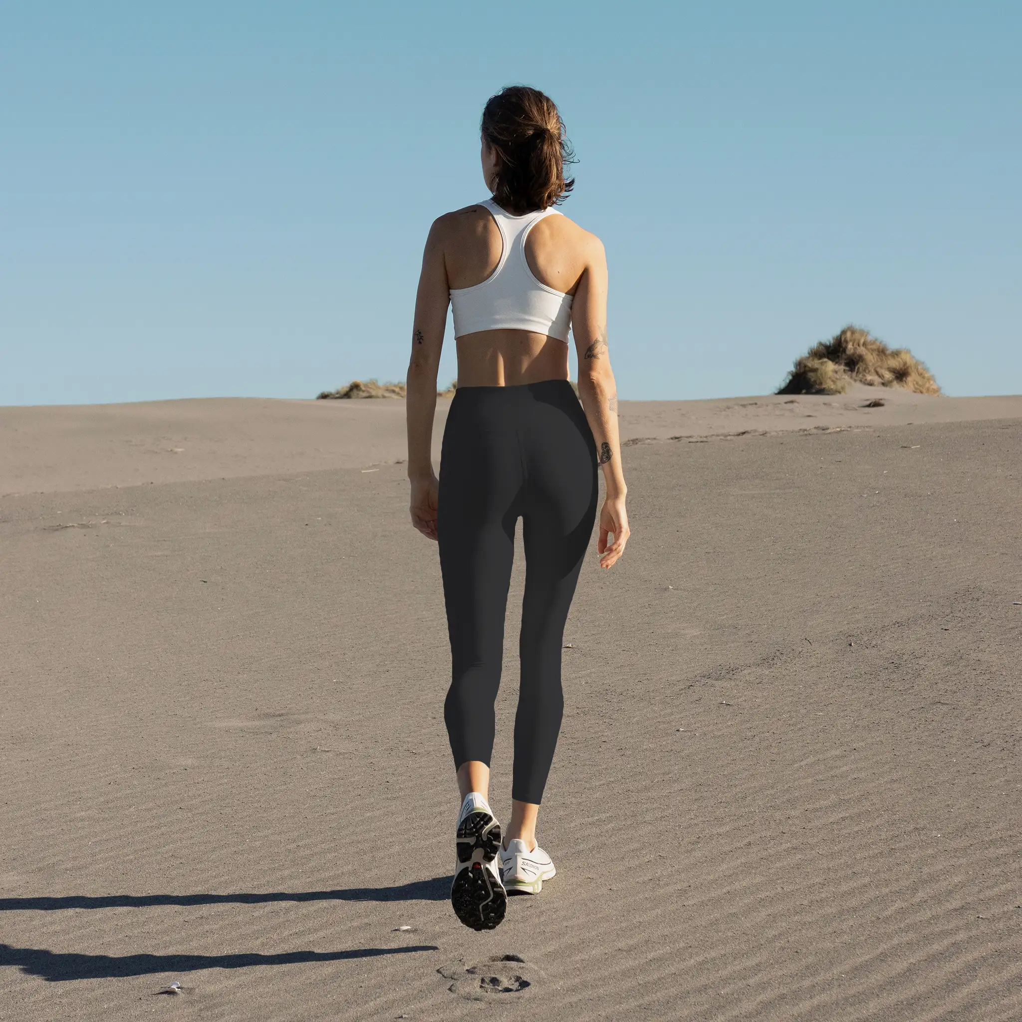Person walking on a dune wearing black Aphrodite leggings